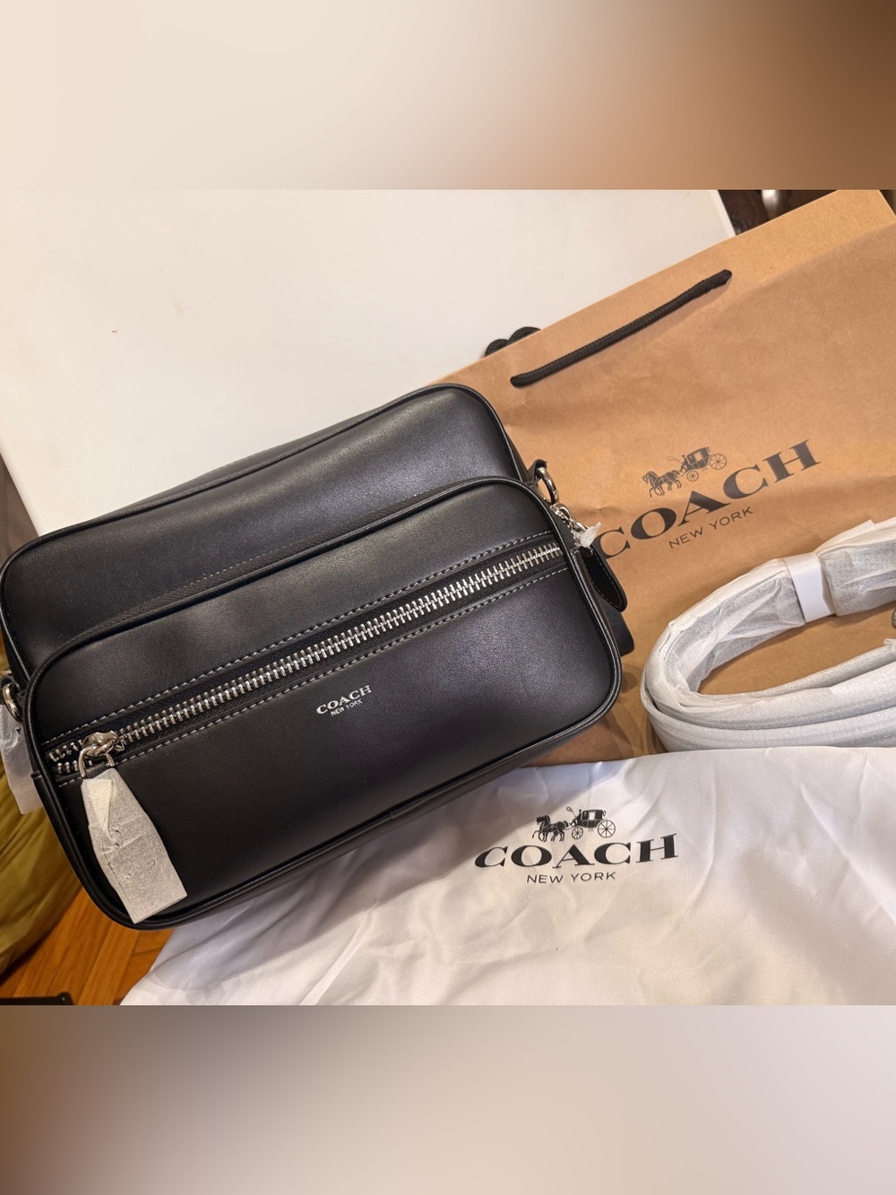 Coach-style black leather messenger crossbody bag with silver-tone hardware.